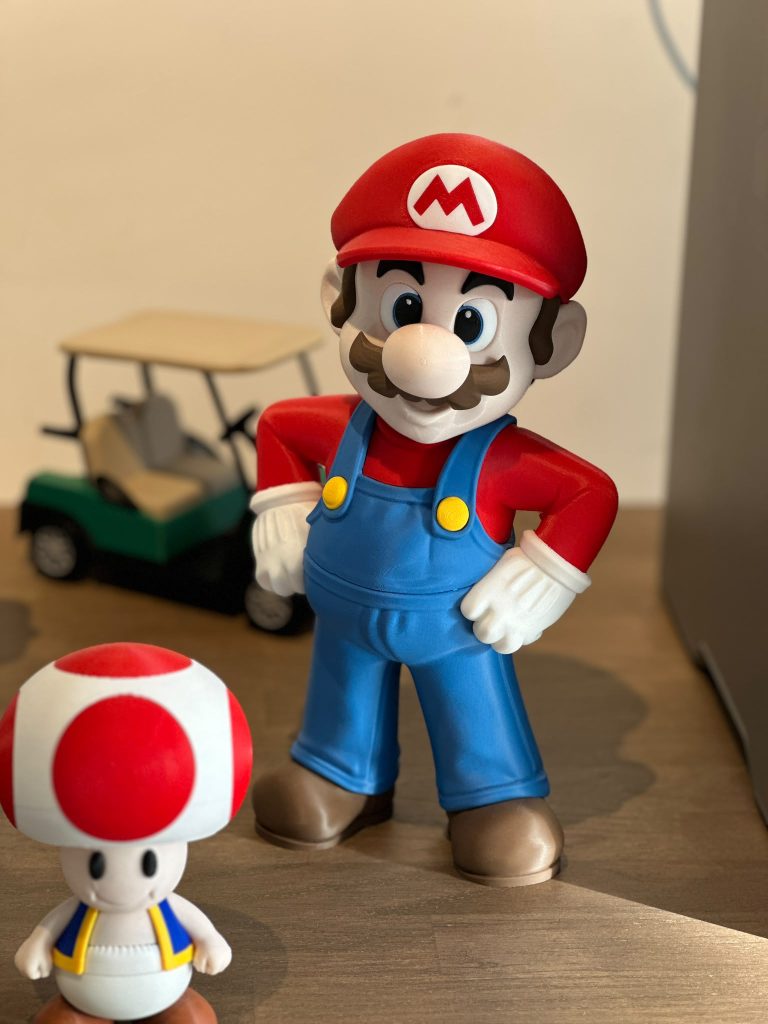 Twee geprinte figuren in rood, blauw en wit