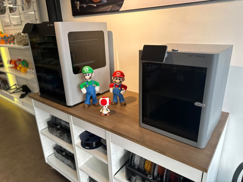 Showroom met printers, filament en geprinte figuren